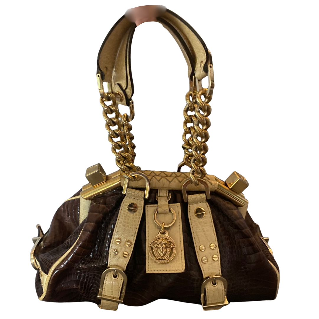 Versace Madonna Bag: Η Ιστορία της Εμβληματικής Τσάντας του 2005Η Συνεργασία Madonna & Versace: Vintage Πολυτέλεια και PowerVintage Versace Madonna Bag καφέ ανάγλυφο δέρμα κροκόδειλου με χρυσές αλυσίδες.Versace Madonna Satchel (ή Boston Bag)καφέ ανάγλυφου δέρματος με κρεμ λεπτομέρειες.ανάγλυφο δέρμα μοσχαριού  Mario Testino Mario TestinoCroc-embossed leather (Ανάγλυφο δέρμα κροκόδειλου), Gold-tone hardware (Χρυσές λεπτομέρειες), Designer vintage handbags.2005 Versace Campaign, Madonna Versace 2005,
